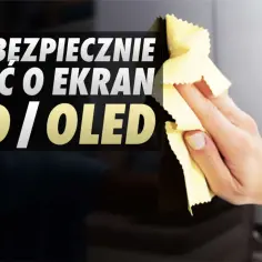 Dłoń czyści ekran telewizora LED/OLED żółtą ściereczką.