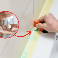 Jak usunąć silikon? Na dłoni widać białą pastę, którą aplikuje się na silikon przed jego usunięciem. Narzędziem usuwa się resztki silikonu.