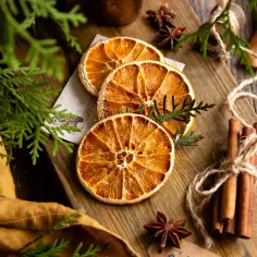 Suszone pomarańcze, laski cynamonu i anyż na desce. Idealne do dekoracji i aromatyzowania potraw, pokazują, jak suszyć pomarańcze w suszarce.
